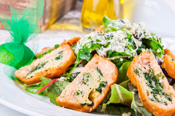Salad leaves with rolls of salmon and spinach