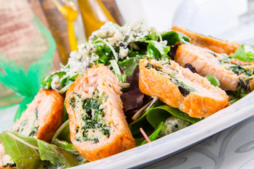 Salad leaves with rolls of salmon and spinach