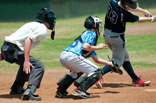 High school baseball catcher with referee during game.