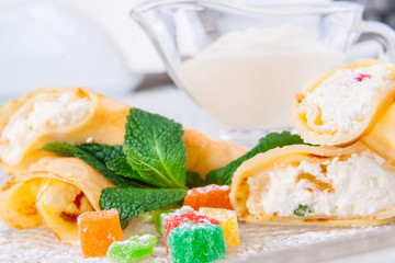 Rolled crepes with cottage cheese and candied fruits