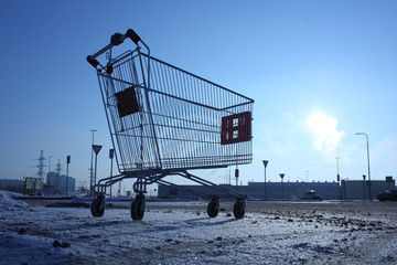 Image of empty shopping cart on empty parking near huge store