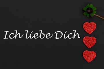 rote Herzen und ein Kleeblatt auf einer Tafel