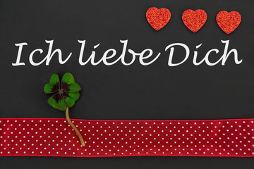 rotes Herz und ein Kleeblatt auf einer Tafel