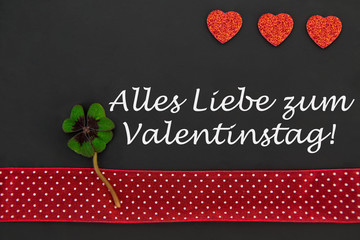 rotes Herz und ein Kleeblatt auf einer Tafel