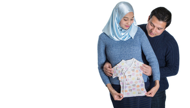 Young happy Muslim pregnant couple over white background