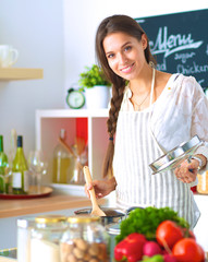 Cooking woman in kitchen with wooden spoon