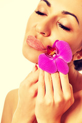 Woman with purple orchid and closed eyes