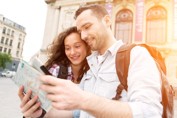 Couple of young attractive tourists watching map
