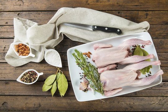 Picant&oacute;n o coquelet, pollo peque&ntilde;o crudo con hierbas y especias en la mesa de la cocina para una comida saludable