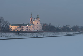 Fototapeta premium Krakow, Poland, frozen Vistula riverbank with Pauline fathers church (Skalka) in the evening