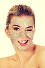 Young happy woman with facial mask.