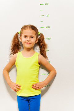 Little girl stand by measuring height scale