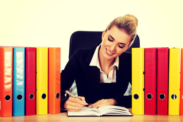 Smile businesswoman with binders by a desk