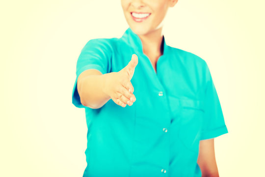 Smile female doctor or nurse giving hand for handshaking