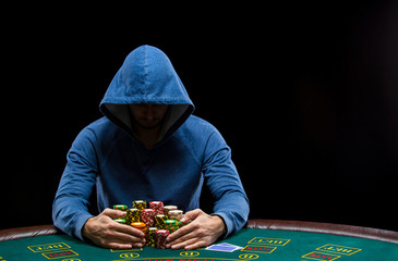 Poker player taking poker chips after winning