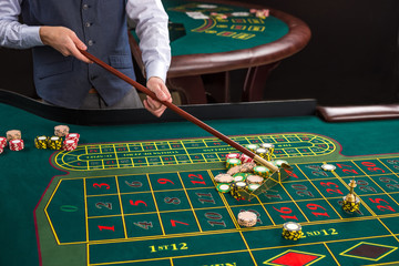 Close up of gambling chips on green table in casino. 