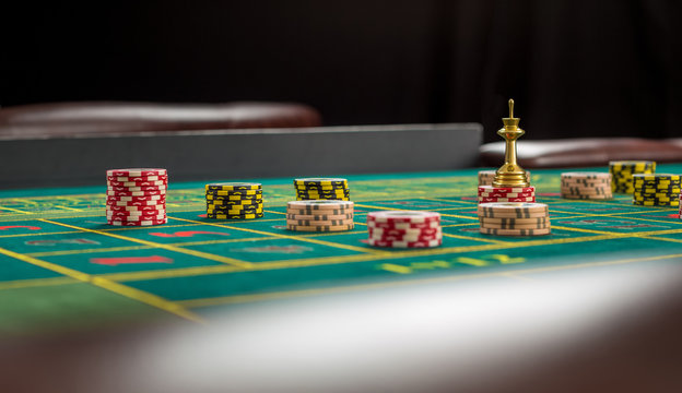 Picture of a green table and betting with chips. 