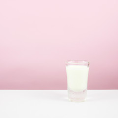 The tasty homemade panna cotta (Italian pudding dessert) in the small glass on white table.