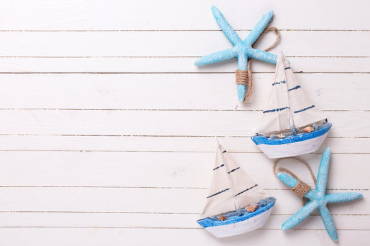 Decorative sailing boats and marine items on wooden background.