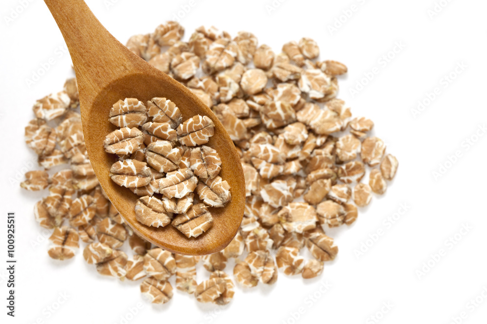 Wall mural wheat flakes in spoon on white background