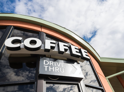 Coffee drive thru sign with cloudy sky