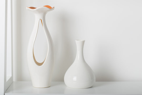 two white vases on white shelf