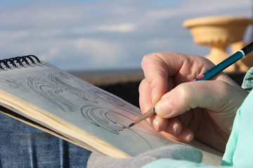 Drawing in a notebook on the waterfront