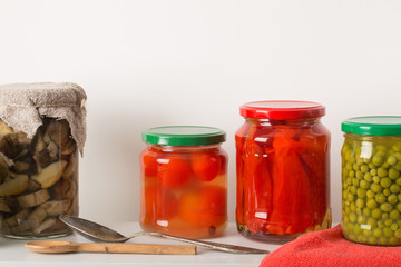 Jars with pickled vegetables on white background