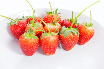 Red strawberries on white plate with white background