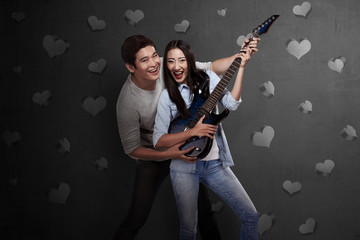 Fototapeta premium Lovely asian couple playing guitar