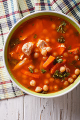 Chickpea soup with chicken and vegetables closeup. vertical top view
