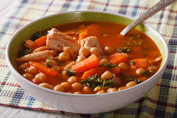 Tomato soup with chickpeas and chicken close-up. horizontal
