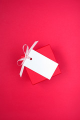 Gift Box with Empty Tag on the Red Background