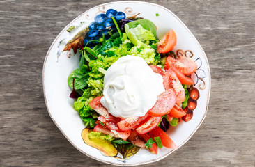 Fresh Vegetables Salad with Sour Cream on wooden table
