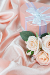 Festive composition with roses and gift box