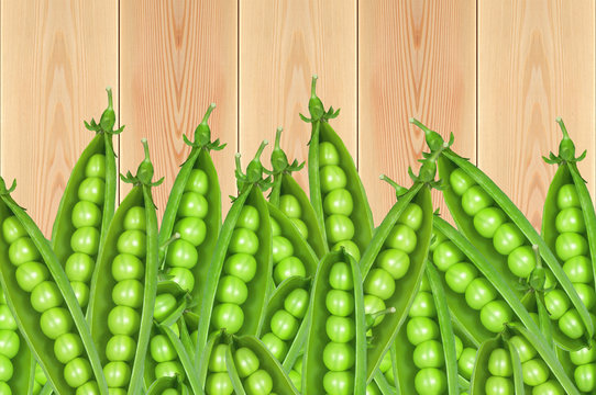 Green fresh peas on wooden table background
