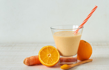 Homemade smoothie made from raw almond milk with orange, carrot and turmeric powder