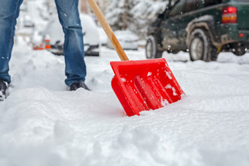 man shoveling snow on road