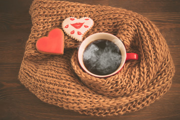 cup of coffee in a scarf and heart cookie, toned