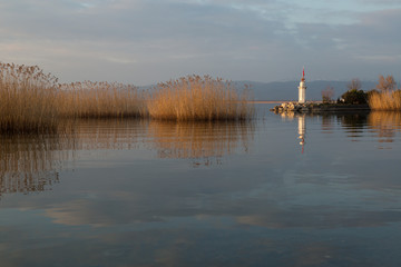 a lighthouse and reeds with their reflections at sunset on Lake Iznik, Turkey