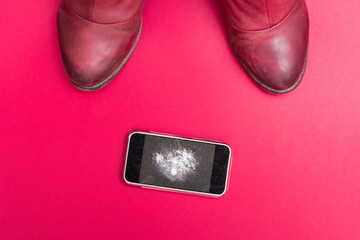Mobile phone with broken screen on floor