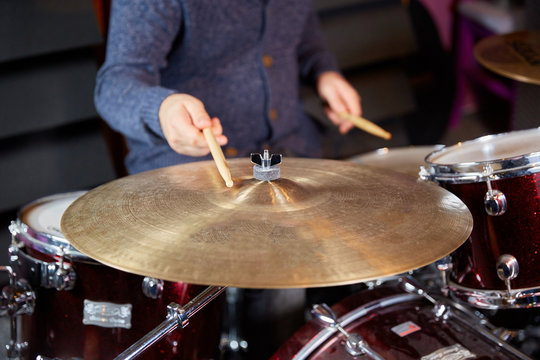 Drummer striking cymbal with drumstick