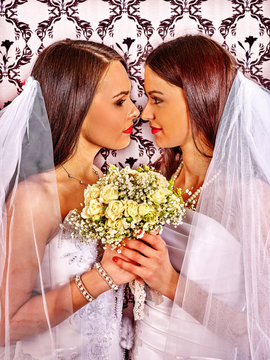 Wedding lesbians girl in bridal dress holding white roses bouquet.