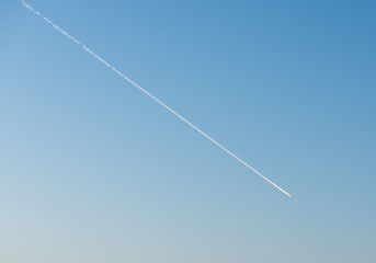 White Condensation Trail From an aeroplane flying across a beautiful blue sky