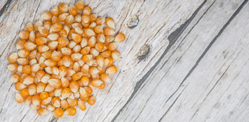 Raw popcorn over wooden background