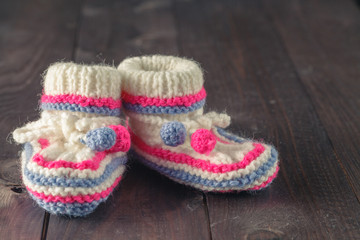 Baby booties on rustic wooden background