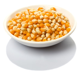 Raw popcorn in white bowl over wooden background