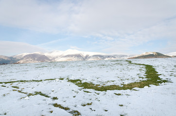 The Lake District, Keswick, England, 01/17/2016, Snowy field with snow covered mountains in the background