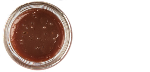 Raspberry fruit curd in glass jar over white background