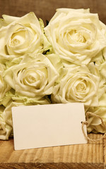 White roses on wooden background. 